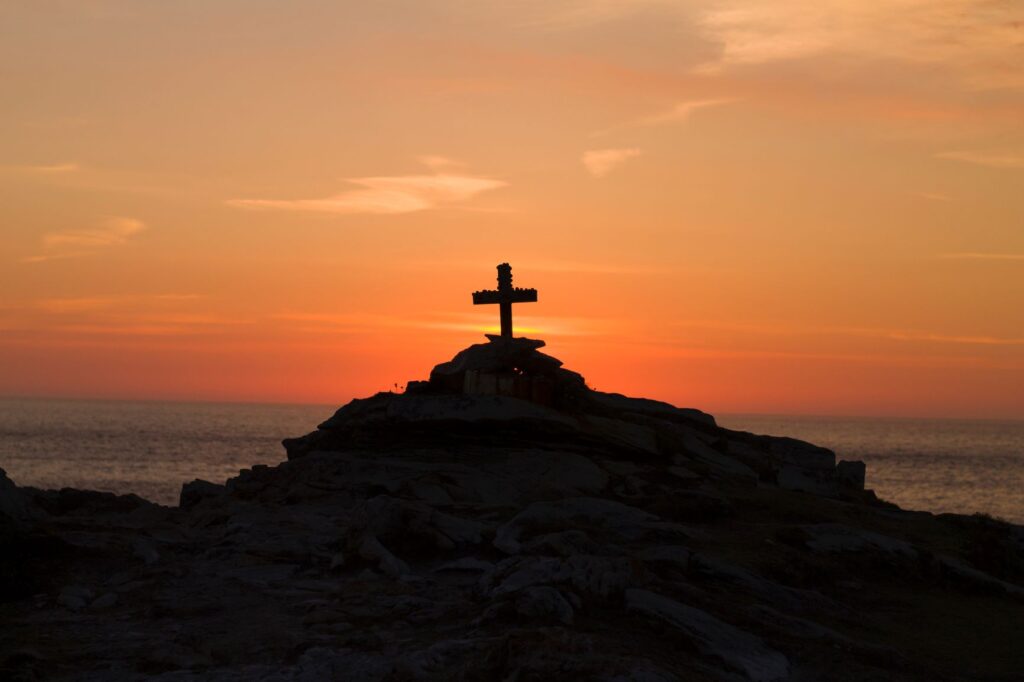 cross on a hill at sunset