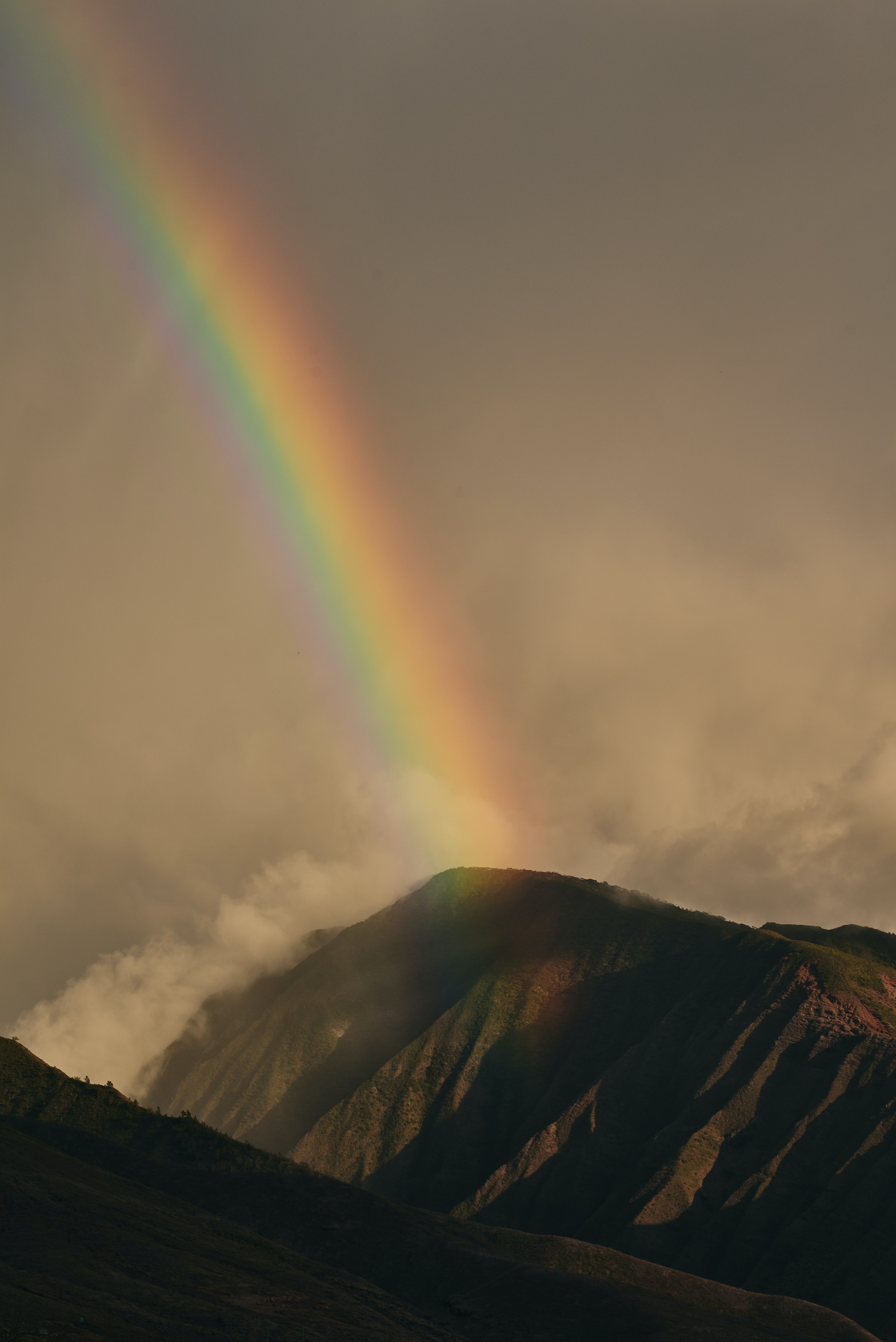 storm clouds and rainbow over mountains