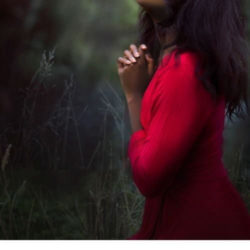 a praying woman in a red dress