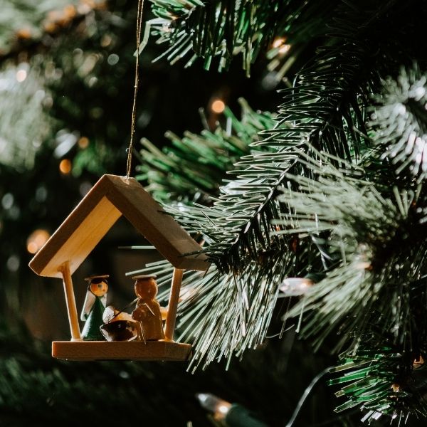 nativity ornament hanging from a Christmas tree